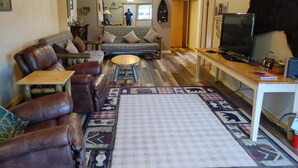 A cozy living room with leather sofas, a coffee table, and a TV. - Welcome to Lenore Lodge, located along the wild & scenic Clearwater River. (Lenore)
