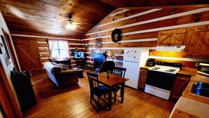 Een gezellig chaletinterieur met een houten eethoek, keuken en woonruimte.