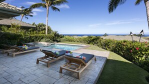 Ein Poolbereich mit Liegestühlen und Blick auf den Ozean.