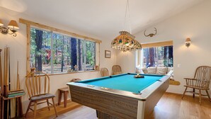 A pool room with a pool table, chairs, and a large window with a view of trees. - Family friendly retreat, private forested acreage (Big Bear Lake)