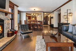 A spacious living room with a fireplace, leather armchair, and a sofa with decorative pillows.