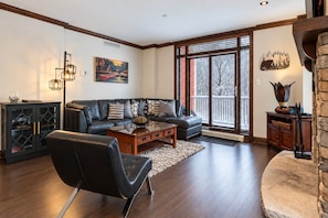 A modern living room with a leather sofa, a coffee table, and a cabinet.