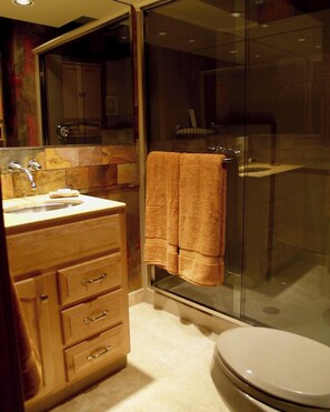 A modern bathroom with a glass shower enclosure, a wooden vanity with drawers, and a toilet. - Walking neighborhood minutes from downtown (Seattle)