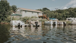 Une maison avec un bateau amarré et un abri à bateaux.