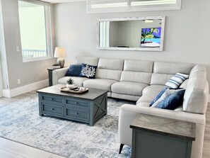 A living room with a sofa, coffee table, and a large mirror on the wall.