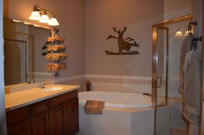 A bathroom with a sink, mirror, towel rack, shower, and a deer decal on the wall. - Beautiful Southwind ski in/out townhome w/ hot tub in 7 Springs gated community. (Seven Springs)