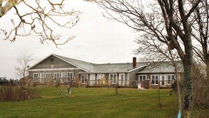 A large, single-story house with a front porch and a covered deck area.