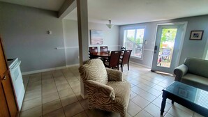 A spacious living area with a dining table, chairs, a sofa, and a coffee table.