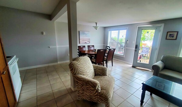 A spacious living area with a dining table, chairs, a sofa, and a coffee table.