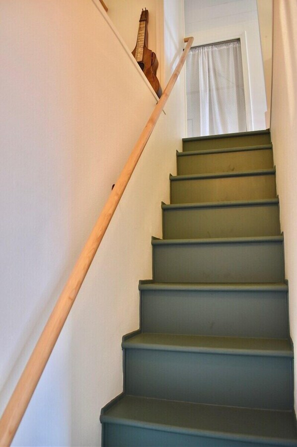 Eine Treppe mit einem hölzernen Geländer und einem Fenster am oberen Ende.