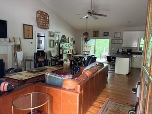 A spacious living area with a fireplace, a dining table, and a kitchen in the background.