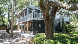 A two-story house with a balcony and a staircase leading to a deck.