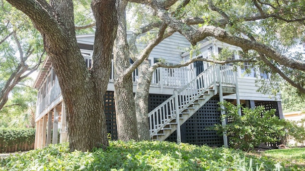 A two-story house with a wooden staircase leading to a balcony.