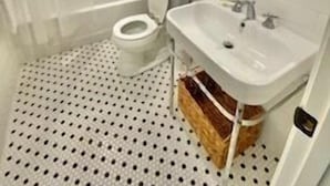 A bathroom with a toilet, sink, and shower.