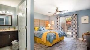A bedroom with a bed, a nightstand, a ceiling fan, and a window with curtains. - Pool and Hot Tub  Beach house 3 bedroom.. 3 bedrooms two bath.   STR19-00084 (Henderson)