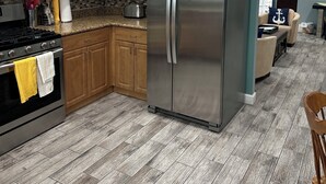 A modern kitchen with white cabinets, a stainless steel refrigerator, a microwave, and a stove. - Pool and Hot Tub  Beach house 3 bedroom.. 3 bedrooms two bath.   STR19-00084 (Henderson)