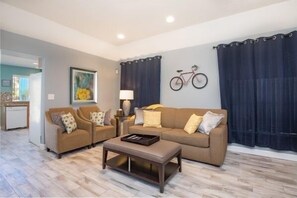 Relax in this inviting living room with a sofa, coffee table, and wall-mounted bicycle.