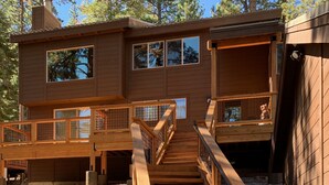 A wooden two-story house with a staircase leading to a balcony. - Serene Vistas at Northstar (Truckee)