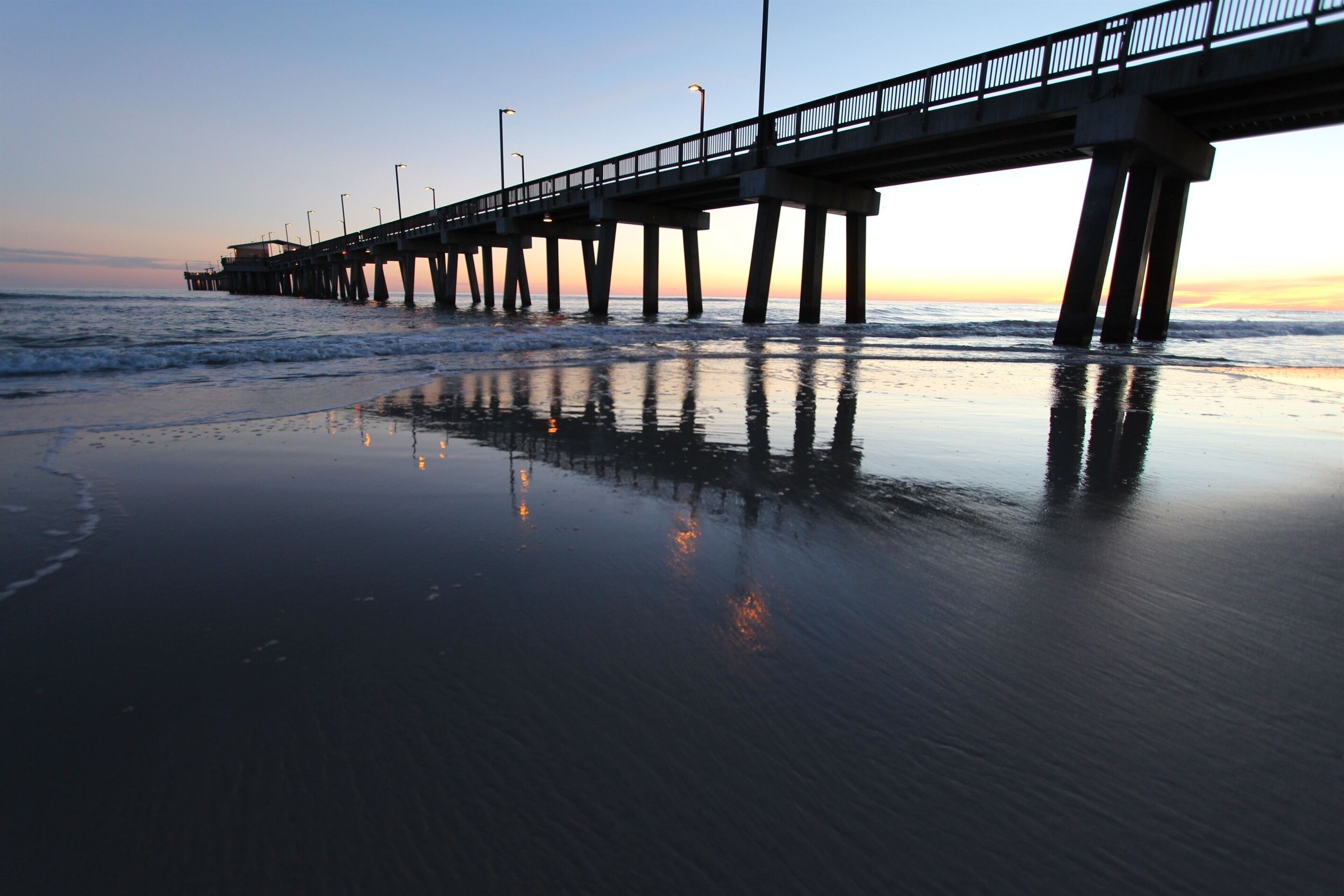 A pier extending into calm waters at dusk.