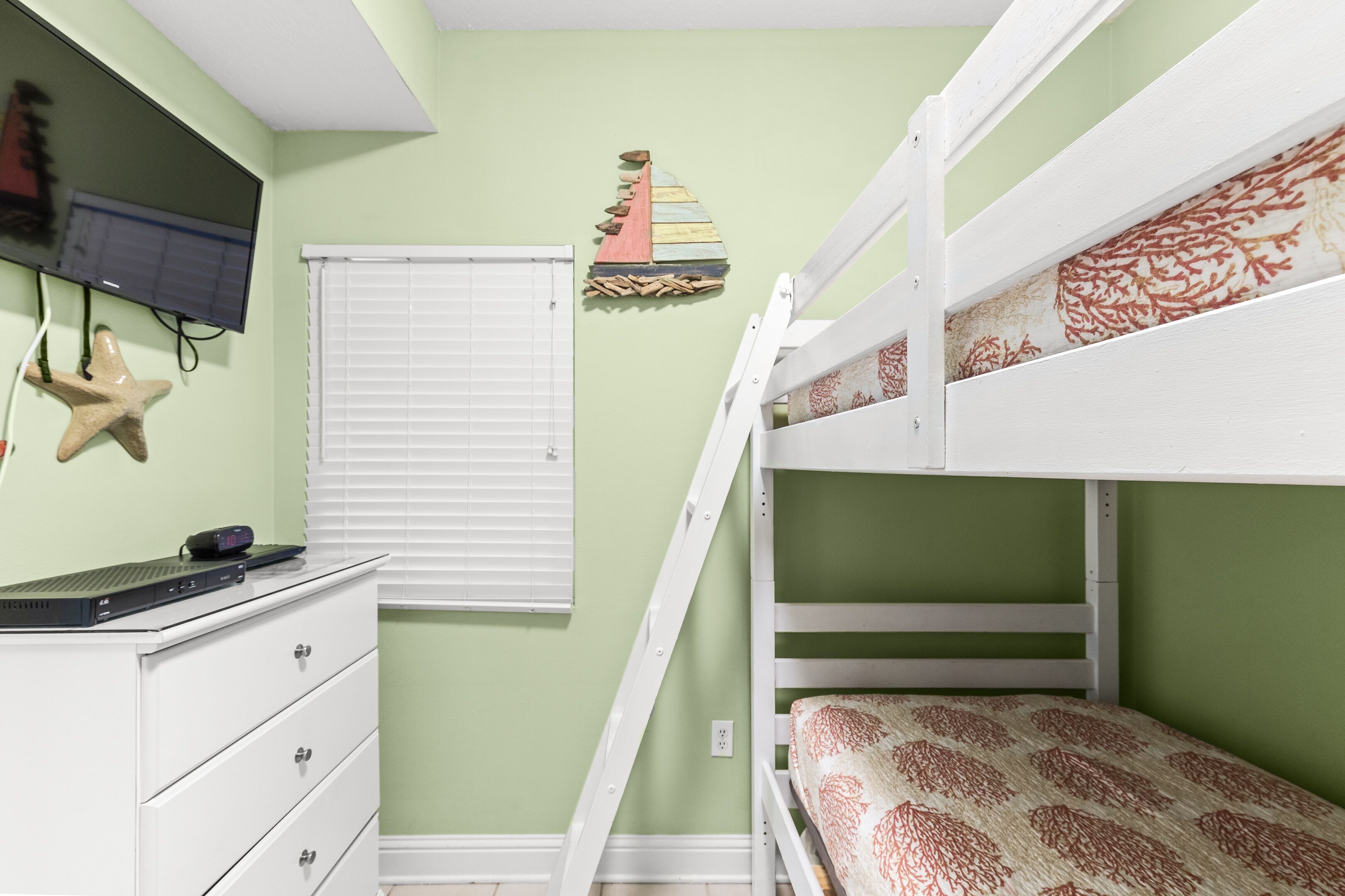 A bunk bed room with a desk and a starfish decoration.