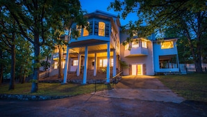 A two-story house with a porch, a driveway, and a fenced yard.