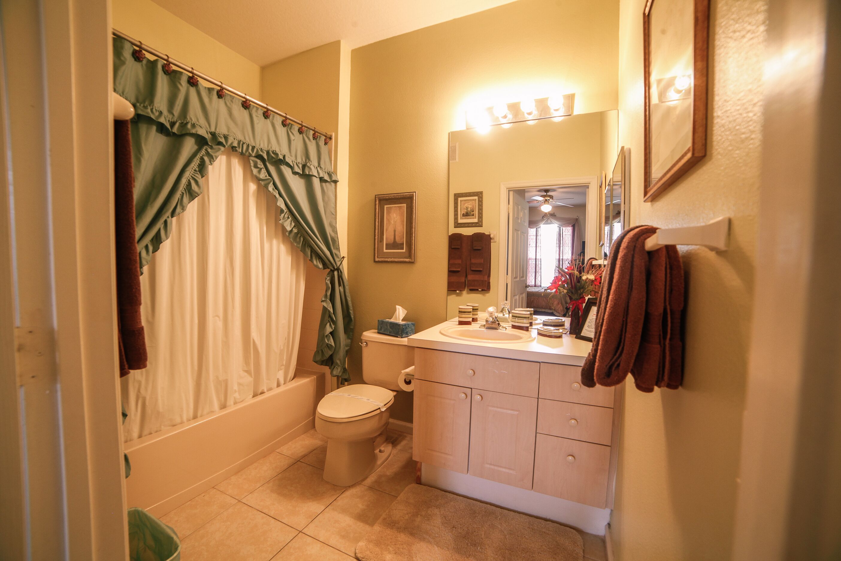 Une salle de bain avec des toilettes, un lavabo et un rideau de douche.
