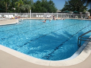 Relax by the pool surrounded by lush greenery and shaded seating areas.