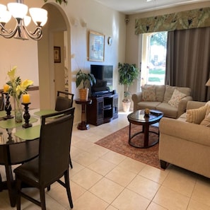 Relax in this inviting living room with a dining area, featuring a dining table, sofa, and television.