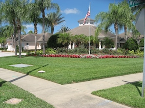 Set amidst lush greenery, this property features a rounded roof and a flagpole with an American flag.