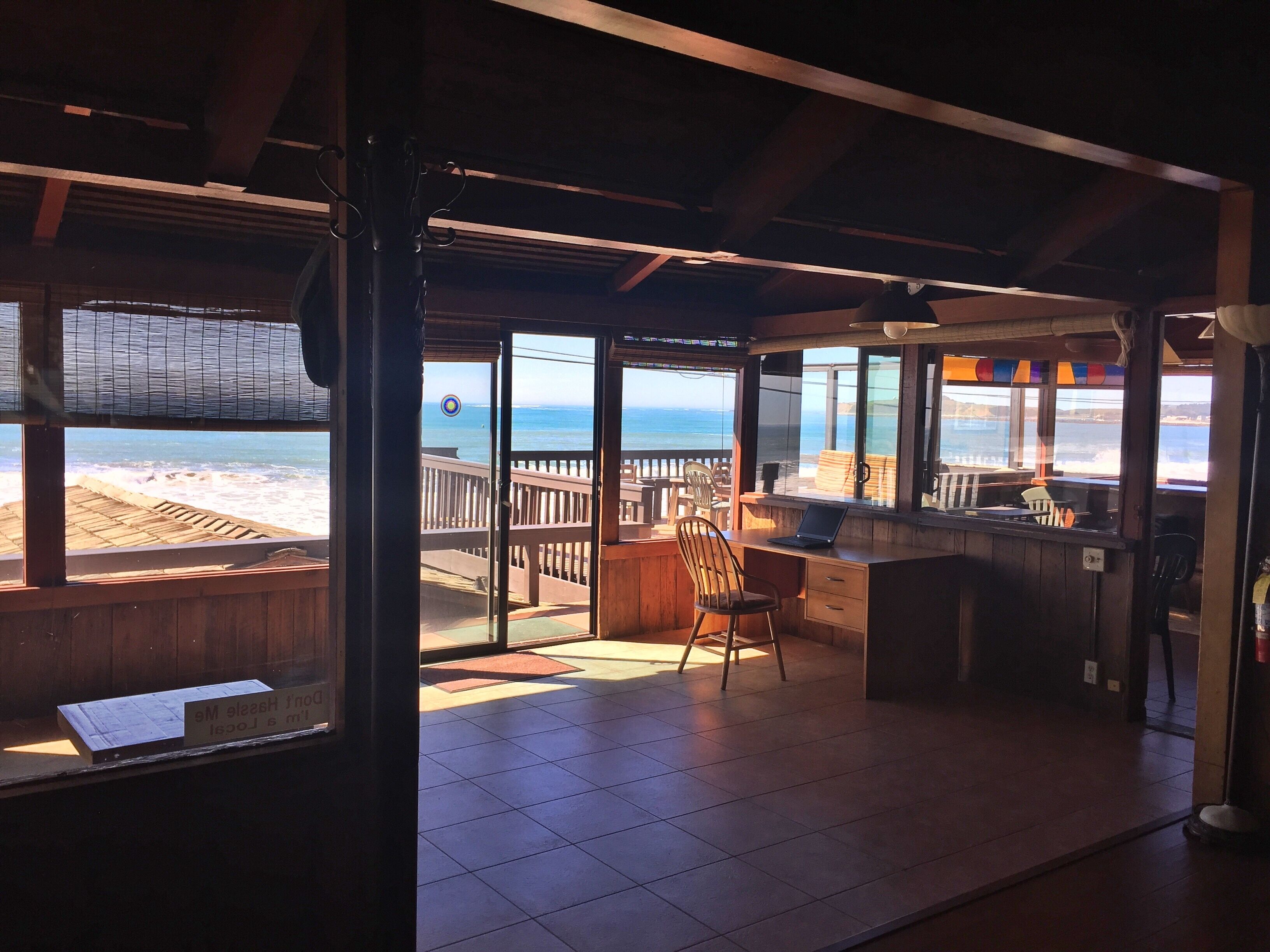 Un restaurant situé en bord de mer, doté d’une terrasse en bois, d’un bar et offrant une vue sur l’océan.