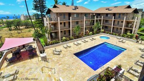 A hotel with a swimming pool, outdoor seating, and a view of the ocean. - Aloha Kai-Private Ocean View Condo in Kihei Steps to the Beach! (Kihei)