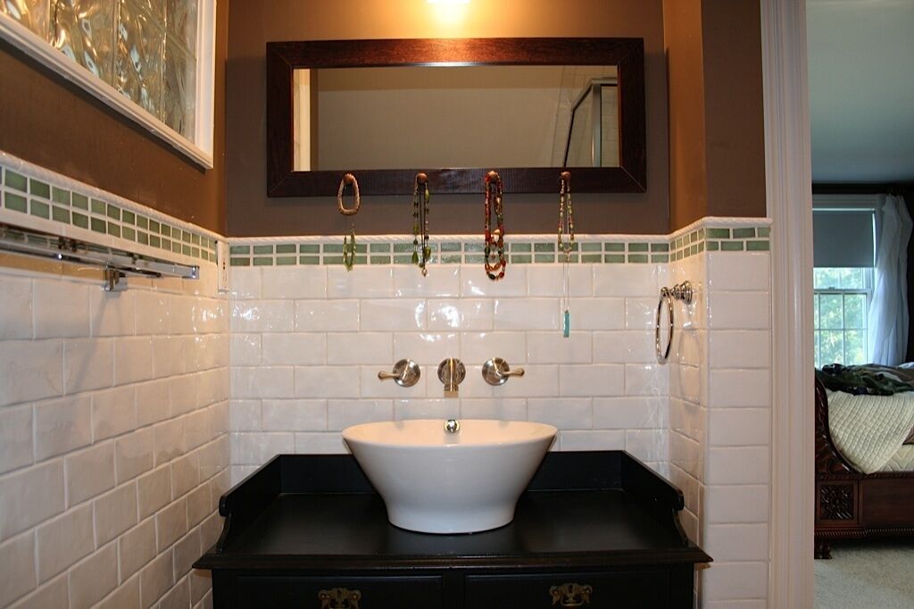 A bathroom with a white sink, a mirror above it, and a tiled backsplash.