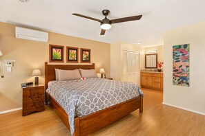 A bedroom with a bed, bedside tables, a ceiling fan, and a nightstand. - Oceanview, no stairs and a Murphy Bed at Maui Kam (Kihei)