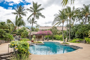 Relax by the serene pool surrounded by lush tropical vegetation and a small waterfall.