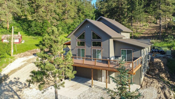 A two-story house with a balcony, surrounded by trees. - Lazy Dog Lodge, Hot Tub, AC & Activities Near Black Hills (Lead)