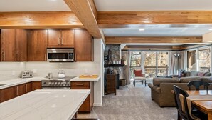 Una cocina moderna con armarios de madera, una isla grande y una pared de acento de piedra.