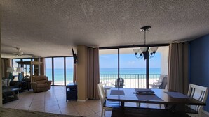 Un salón amplio con una gran mesa de comedor, asientos cómodos y vistas a la playa.