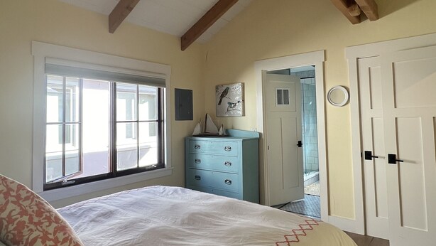 A bedroom with a bed, a dresser, a ceiling fan, and a window. - Downtown charming, 2 BR 2 BA Flat, 1 Block from Ocean Ave, Carmel-by-the-Sea, CA (Carmel-By-The-Sea)