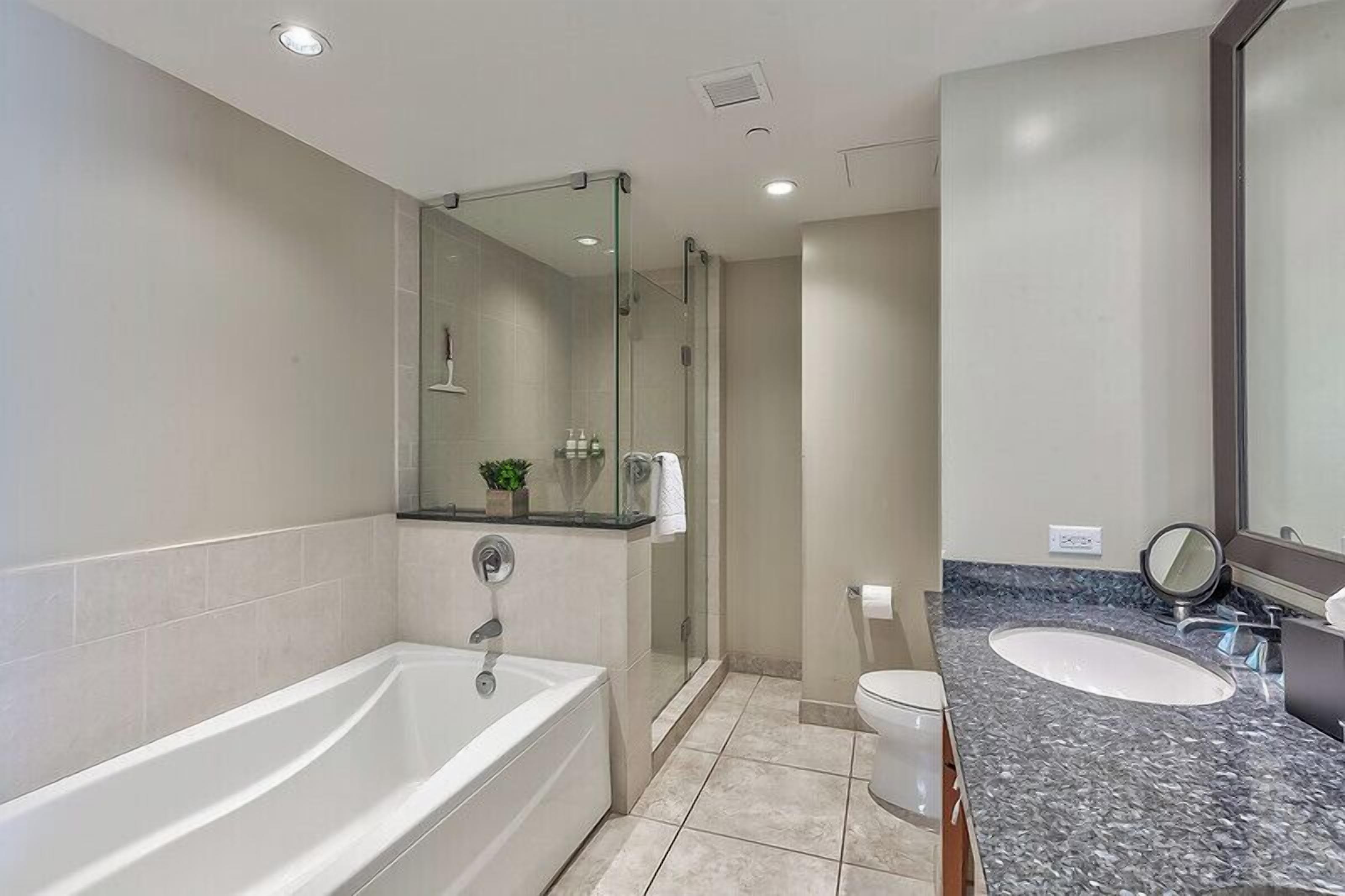Ein modernes Badezimmer mit Badewanne, Dusche und Waschbecken.