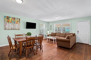 Relax in this inviting living room with a flat-screen TV, dining table, and comfortable sofa.