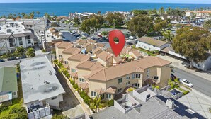 A residential area with a red location marker, houses with red-tiled roofs, and a view of the ocean. - Spacious Village beach house. Private rooftop deck. Walk to beaches and shops.  (Carlsbad)