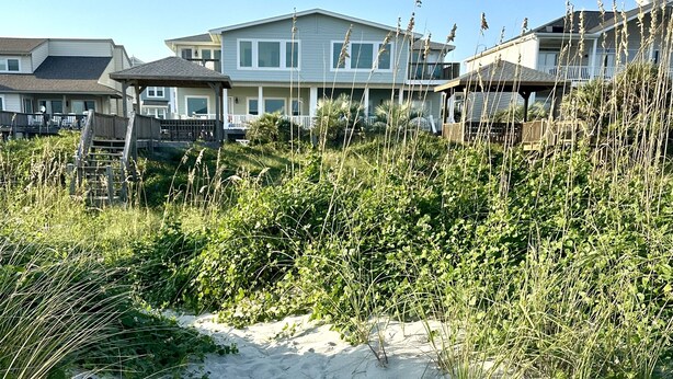 A beachfront property with multiple houses, sandy beach, and dense vegetation. - OCEAN FRONT with POOL, Great LOCATION near pier, 5 bed & 5 bath (Ocean Isle Beach)