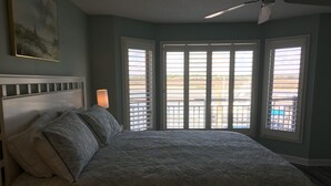 Une chambre à coucher avec un lit, une table de chevet, une lampe et un tableau au mur.