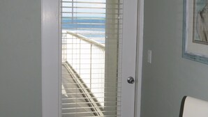 Eine Tür mit Blick auf einen Balkon und einen Strand.