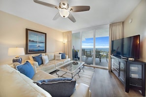 Relax in this stylish room with a sofa, flat-screen TV, and sliding glass door to a balcony with a dining area.