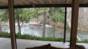 A covered outdoor area with a view of a river and trees. - Riverfront North Fork Kaweah - 1500 Ft of your own river! (Three Rivers)