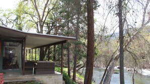 A riverside cabin with a covered porch, stone steps, and a view of the river. - Riverfront North Fork Kaweah - 1500 Ft of your own river! (Three Rivers)