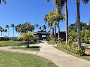 Ein Resort mit überdachtem Gang, Palmen und Blick auf den Ozean.