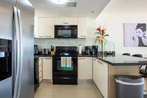 Una cocina moderna con electrodomésticos de acero inoxidable, microondas y cafetera.