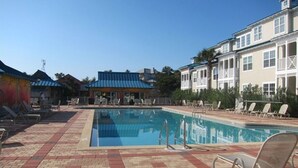 A swimming pool with lounge chairs and a building with a blue roof in the background. - Amazing Location in Beautiful Blue Mountain Beach.  75 Yards from the Sand...   (Santa Rosa Beach)